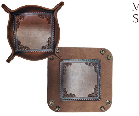 The Franklin is a little different than our other trays because of the Hand Stamped and stained inside layer. Outer layer is a Bison brown color with the inside layer being stitched in. The corners are held together with heavy line 24 Antique Brass colored snaps, for laying flat for travel, a place for placing keys, wallet, coins, etc. Made in our shop just outside Nashville in Smyrna, TN.