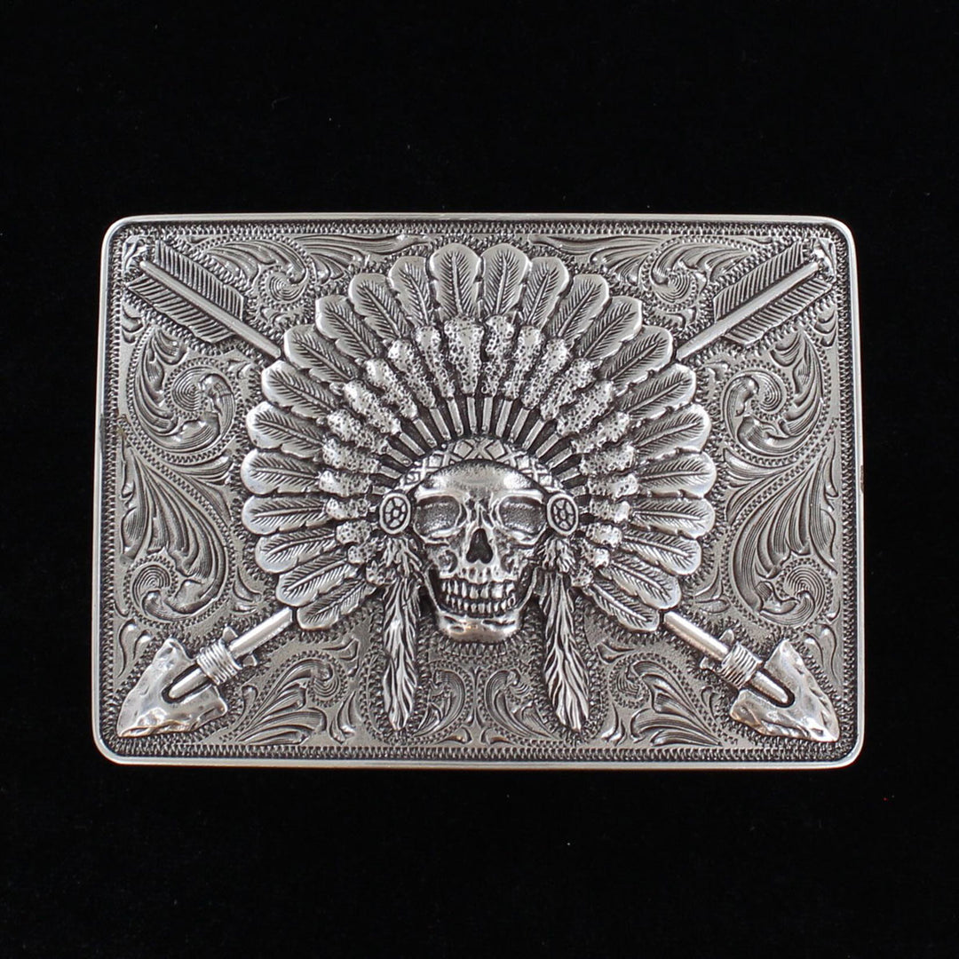 Ariat Indian Chief belt buckle Rectangle shaped buckle with a stylish smooth edge. It features a centered Indian chief skull with headdress and crossing arrows motif surrounded by western scroll engraving. Antiqued Chrome color. Measures 3-1/2" wide x 2-1/2" tall Fits belts up to 1 1/2" wide Available online or in our shop in Smyrna, TN just outside Nashville. Alternate view.