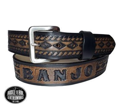 "The Banjo" is a handmade real leather belt made from a single strip of cowhide shoulder leather that is 8-10 oz. or approx. 1/8" thick. It has hand burnished (smoothed) edges and a Diamond center with a rope edge pattern. This belt is completely HAND dyed with a multi step finishing technic. The antique nickel plated solid brass buckle is snapped in place with heavy snaps.  This belt is made just outside Nashville in Smyrna, TN.