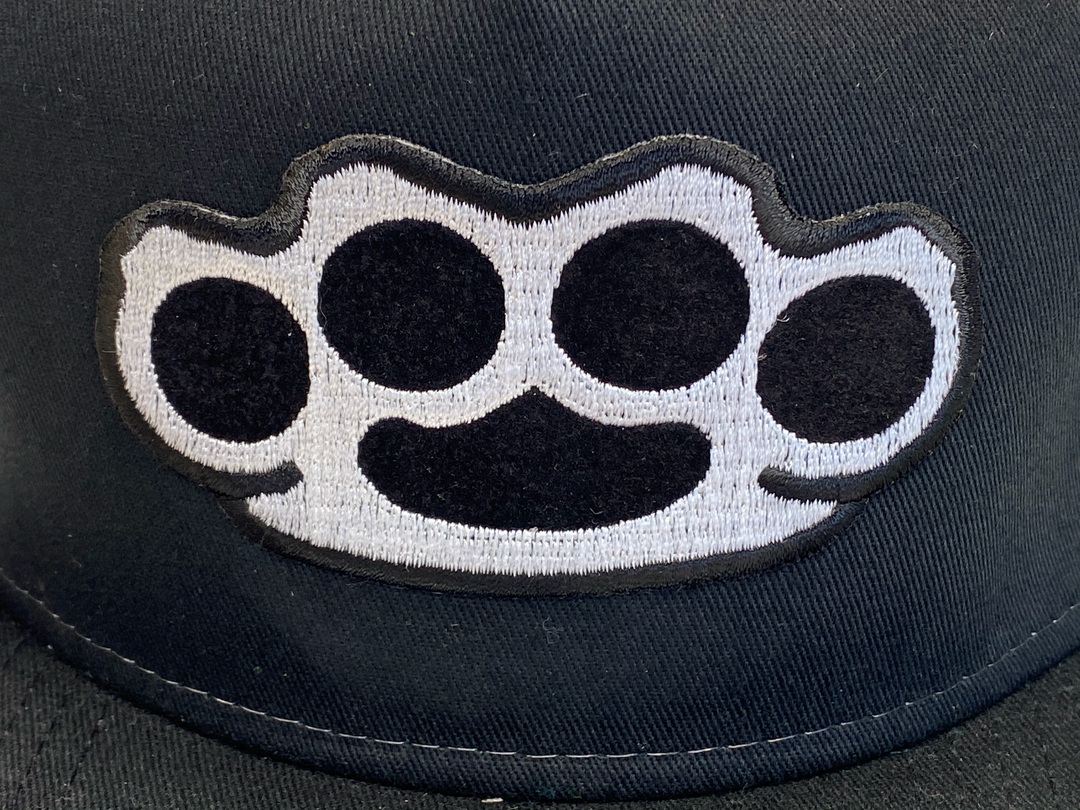 Black Flat Bill Cap with Gray mesh back. Front has a Silver embroidered Brass Knuckles patch. "HARDCORE" design also under the bill. Structured top to keep its shape. Sold at our shop just outside Nashville in Smyrna, TN.