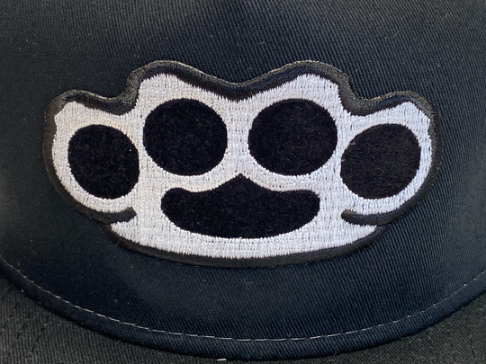 Black Flat Bill Cap with Gray mesh back. Front has a Silver embroidered Brass Knuckles patch. "HARDCORE" design also under the bill. Structured top to keep its shape. Sold at our shop just outside Nashville in Smyrna, TN.