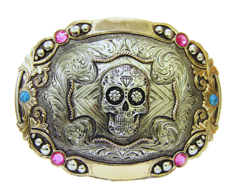 The Calavera buckle features a Sugar Skull accented by detailed Western scroll work and ornate border work with Pink and Blue stones.  Augus buckles are made from German Silver (nickel and brass alloy) or iron metal base. Some buckles have motifs made of copper, iron or brass. Each piece is punched, cut, soldered, engraved, polished and painted by our talented metal workers. Available at our Smyrna, TN location.