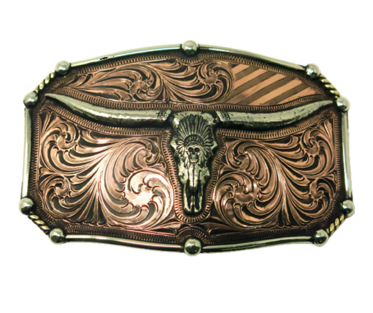 The Chief Longhorn buckle  These buckles are made from German Silver (nickel and brass alloy) or iron metal base. Some buckles have motifs made of copper, iron or brass and some are adorned with synthetic stones. These are all handcrafted. Each piece is punched, cut, soldered, engraved, polished and painted by our talented metal workers.  Available in our Smyrna TN shop. Width 4.5” Height 3”
Fits Standard 1.5” belts