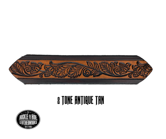 This solid strip of Veg Tan cowhide, is hand stained in 3 brown options, with smooth, finished edges. Embossed with Western Vine down length of belt, or have name added to scene up to 8 letters. Belt thickness is approx. 1/8", and 1 1/2" wide. Sizes available are 34" to 44" from buckle end to hole most worn. Attached with 2 snaps is a Brushed Nickel plated solid brass buckle. 