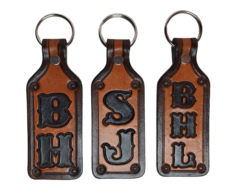 Our Customizable "1973" Medium Leather keychain embossed similar to our popular belts.  Great for identifying luggage, backpacks, or your keys! Available in the below choices All colored in our popular 2 TONE BROWN, pick one or a few. Made in our Smyrna, TN shop. 2 initials will be 1" size, 3 initials will be 3/4" size. Please type desired name in CUSTOM box.  Measures...approx. 1" x 4"