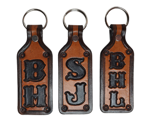 Our Customizable "1973" Medium Leather keychain embossed similar to our popular belts.  Great for identifying luggage, backpacks, or your keys! Available in the below choices All colored in our popular 2 TONE BROWN, pick one or a few. Made in our Smyrna, TN shop. 2 initials will be 1" size, 3 initials will be 3/4" size. Please type desired name in CUSTOM box.  Measures...approx. 1" x 4"