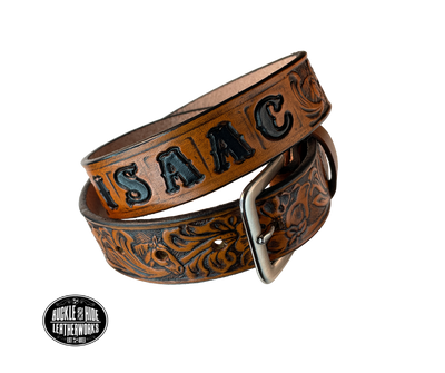Introduce your little one to the iconic style of the west with the "Lil' Mustang" Leather KIDS/CHILDRENS Name Belt! Durable veg tan leather ensures that your cowboy or cowgirl can look good while feeling comfortable, and a unique western floral design featuring horses adds a touch of fun. A 1 1/4" width with snaps makes swapping out buckles a snap! Proudly made in Smyrna TN, just outside Nashville. 