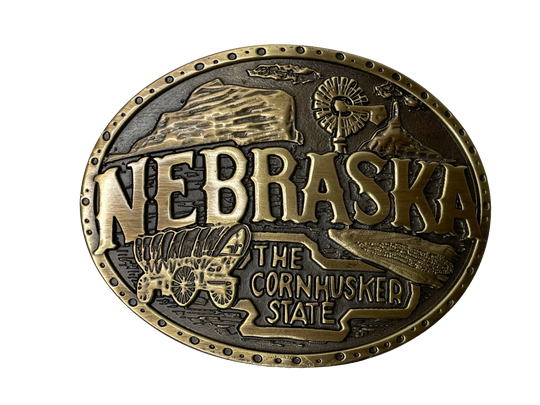 Nebraska State buckle by AndWest Dimensions are 3" tall by 3 3/4" wide Fits belts up to 1 1/2" wide Buckle is brass colored with Nebraska Cornhusker State embossed across front of buckle. Farming scene in the back behind "Nebraska". Back of buckle has Western scroll design Available in our online store and in the retail shop in Smyrna, TN, just outside of Nashville. Made in Mexico