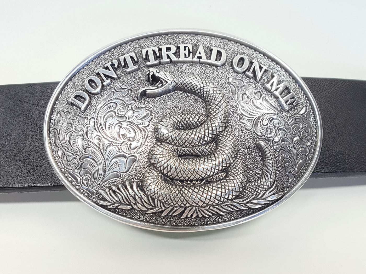 Oval shaped Nocona buckle Smooth edge and "Don't Tread On Me" motif Measures 2 1/2" tall by 3 1/2" wide Made in Taiwan Available online and in our shop in Smyrna, TN, just outside of Nashville