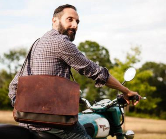 This 2 tone brown leather messenger bag is made from real cowhide leather.&nbsp; Flap is a smooth oil tanned leather with a distressed look and the body has contrasting soft pebbled grain leather. The flap secures with a magnetic snap. Dimensions are approx. 15" by 12" by 3". Back pocket will hold a full size laptop.&nbsp; Inner bag is lined with nylon and leather trim and hardware is brushed nickel. Available for purchase in our retail shop in Smyrna, TN, just outside Nashville.