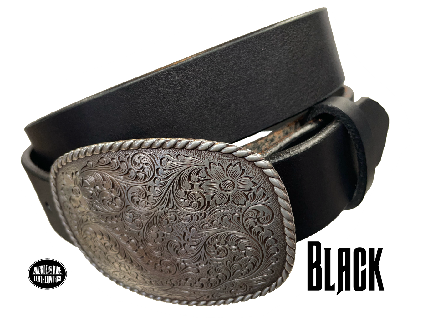 This rectangular shaped buckle by Nocona has rounded edges with rope design around the border. It is chrome colored with scroll design etched appearance on surface.  Measures 2 3/4" tall by 3 3/4" wide and fits belts up to 1 1/2" wide. Buckle is made in Taiwan. Belt is a single strip of leather that is 1 1/2" wide and available in sizes 34" to 44". Colors are distressed brown, black, and dark brown. Black pictured. Available online and in our retail shop in Smyrna, TN, just outside Nashville.