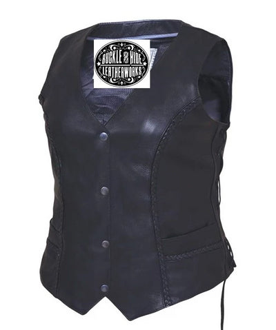 Ladies black soft cowhide leather vest with v-neck and snap front closure. It has solid sides and 2 outside front pockets. It has multi paneled back with braid accents and side laces.  Available for purchase in our shop in Smyrna, TN, just outside Nashville.  Available in sizes XS-5X.