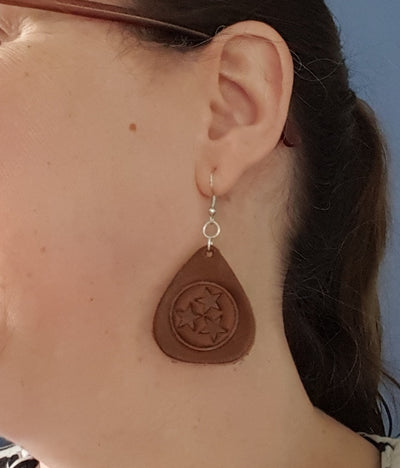 Tennessee Tri-Star Guitar pick earrings. Cut in the shape of a guitar pick and embossed with the Tennessee Tri-Star Logo. Made from Tennessee tanned cowhide leather in Smyrna Tenn. That's a lot of Tennessee! Nickle free ear wires.