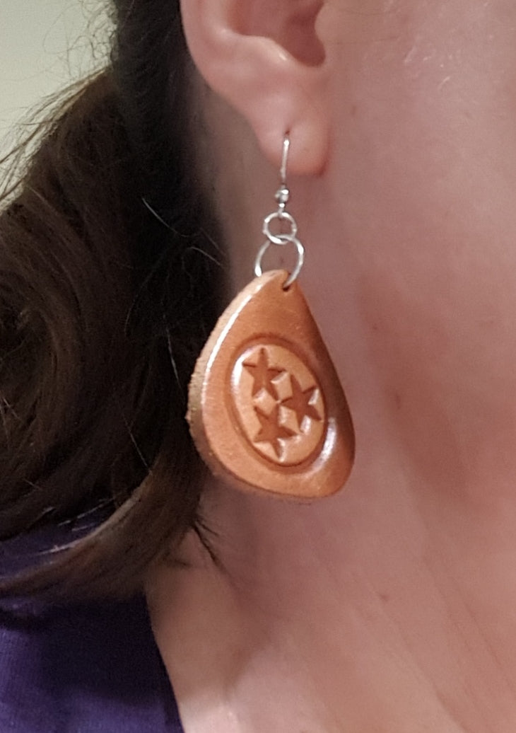 Tennessee Tri-Star Guitar pick earrings. Cut in the shape of a guitar pick and embossed with the Tennessee Tri-Star Logo. Made from Tennessee tanned cowhide leather in Smyrna Tenn. That's a lot of Tennessee! Nickle free ear wires.