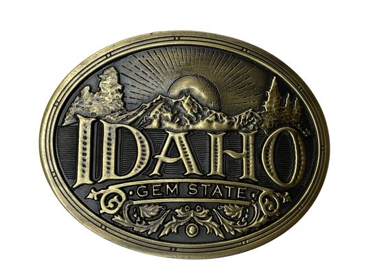 Idaho State buckle by AndWest Dimensions are 3" tall by 3 3/4" wide Fits belts up to 1 1/2" wide Buckle is brass colored with Idaho Gem State embossed across front of buckle. Mountain scene in the back behind "Idaho". Back of buckle has Western scroll design Available in our online store and in the retail shop in Smyrna, TN, just outside of Nashville. Made in Mexico