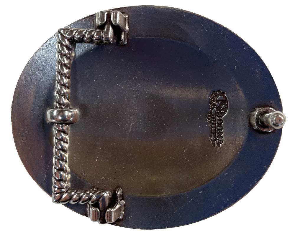 This oval buckle by Nocona's Blazin' Roxx measures 2 1/2" tall by 3" wide. Background color is chrome. It has a decorative turquoise colored stone in the center surrounded by brown crystals, Lines radiate from the center outward and more turquoise colored crystals are then around the buckle with a rope design separating them from the edge of the buckle, which has another row of brown crystals in the design. Available online and in our retail shop in Smyrna, TN, just outside of Nashville.