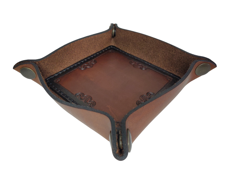 This Valet is different than our Gulch tray because of the HAND SATAMPED border design with Hand Finishing done on the VEG -TAN inside. Antique Brass SNAPPED corners to FLATTEN out for easy packing for travel. It is made in our Smyrna, TN shop just outside Nashville.  The Stitched inside leather matches the outside for rustic look. It is a perfect catch-all for keeping keys and other small items in one place at the end of a long day.  Makes a great gift for groomsmen, or that special someone.
