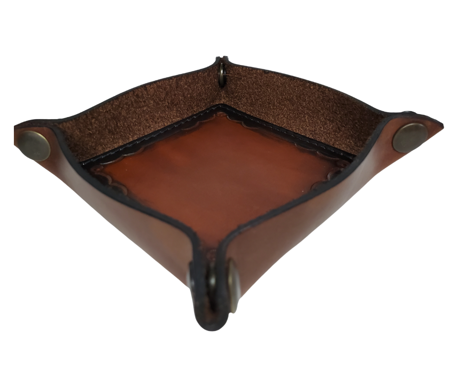 This Valet is different than our Gulch tray because of the HAND SATAMPED border design with Hand Finishing done on the VEG -TAN inside. Antique Brass SNAPPED corners to FLATTEN out for easy packing for travel. It is made in our Smyrna, TN shop just outside Nashville.  The Stitched inside leather matches the outside for rustic look. It is a perfect catch-all for keeping keys and other small items in one place at the end of a long day.  Makes a great gift for groomsmen, or that special someone.