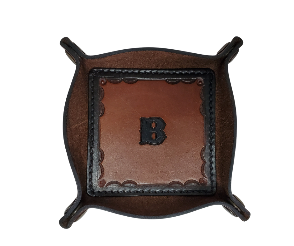 This Valet is different than our Gulch tray because of the HAND SATAMPED border design with Hand Finishing done on the VEG -TAN inside. Antique Brass SNAPPED corners to FLATTEN out for easy packing for travel. It is made in our Smyrna, TN shop just outside Nashville.  The Stitched inside leather matches the outside for rustic look. It is a perfect catch-all for keeping keys and other small items in one place at the end of a long day.  Makes a great gift for groomsmen, or that special someone.