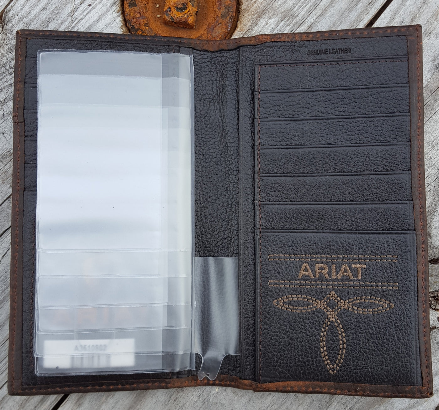 Ariat Rodeo Wallet with overlay, inside right view- Ariat Rodeo style wallet  Wallet is distressed brown leather with Ariat shield concho. Multiple credit card slots, clear drivers license slot and removable picture holder.  Folded wallet measures 7" tall by 3" wide. Interior has 12 card slots, one open cash pocket, and an identification window.