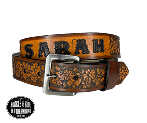 "The Beulah Land" is a handmade real leather belt made from a single strip of cowhide shoulder leather that is 8-10 oz. or approx. 1/8" thick. It has hand burnished (smoothed) edges and summer flowers embossed in 3 color options.  The antique nickel plated solid brass buckle is snapped in place with heavy snaps.  This belt is made just outside Nashville in Smyrna, TN.