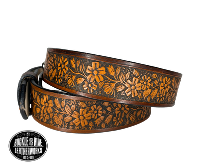 "The Beulah Land" is a handmade real leather belt made from a single strip of cowhide shoulder leather that is 8-10 oz. or approx. 1/8" thick. It has hand burnished (smoothed) edges and summer flowers embossed in 3 color options.  The antique nickel plated solid brass buckle is snapped in place with heavy snaps.  This belt is made just outside Nashville in Smyrna, TN.