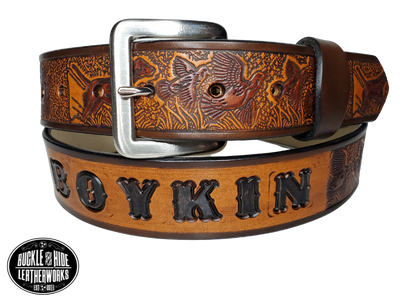 "The Retriever" is a handmade real leather belt made from a single strip of cowhide shoulder leather that is 8-10 oz. or approx. 1/8" thick. It has hand burnished (smoothed) edges and a Bird Hunting scene with a Bird Dog and Quail/Grouse pattern. This belt is completely HAND dyed with a multi step finishing technic. The antique nickel plated solid brass buckle is snapped in place with heavy snaps.  This belt is made just outside Nashville in Smyrna, TN.