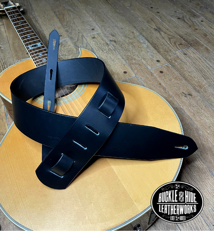 Nothing is more classic than Solid Black. "The CASH" Guitar Strap is just that it's made from 1/8" thick drum dyed vegetable tanned cow hide and has a smooth, glossy finish.  The main strap is made from a single strip of leather with beveled and painted edges.  Choose a 2" or 2 1/2" wide strap with a classic adjustment style. Made just outside Nashville in Smyrna, TN.