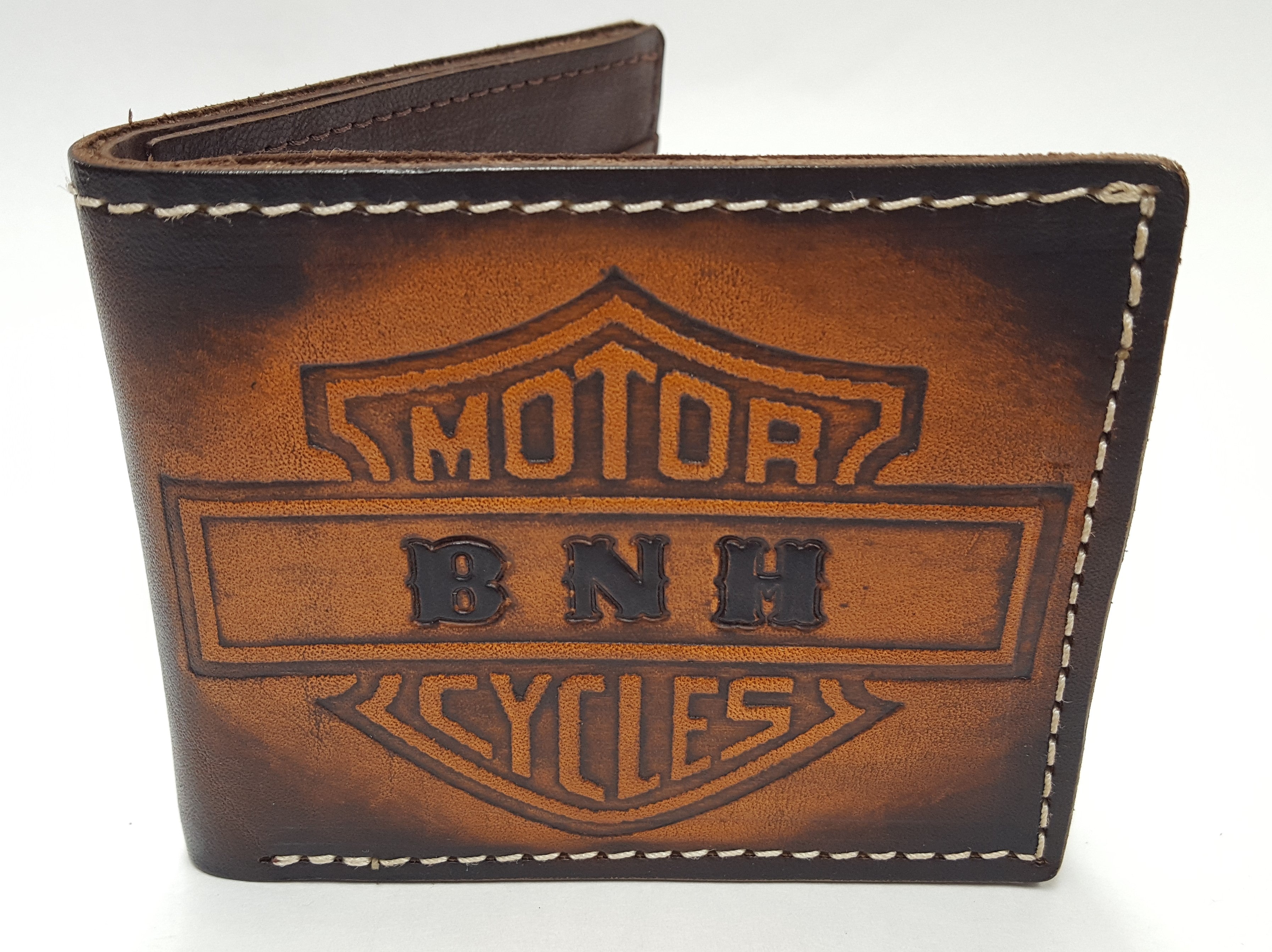 Motorcycle design wallet-This handmade leather bifold wallet starts with an embossed, brown hand-dyed exterior and has a brown goat interior.  It is made in our shop in Smyrna, TN, just outside Nashville. You may have your initials stamped on the Motor Cycles style wallet. Interior has 3 card slots on right side, fold over 2 sided ID flap on left interior and 2 card slots on left. It contains a cash pocket as well along the top. Stitched with white exterior thread and brown interior thread.