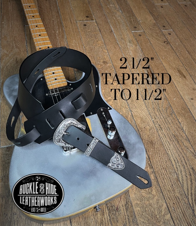 You don't get more classic Western than a handcrafted Glossy black leather guitar strap! Featuring a ornate scroll pattern 3 piece western buckle set in the front position of the strap. Each size of buckle set is similar but not the same, so check out pictures. It's made from 1/8" thick drum dyed cowhide leather and looks great with a vintage "Tele". The main strap is made from a single strip of leather with beveled and .  Made just outside Nashville in Smyrna, TN. 