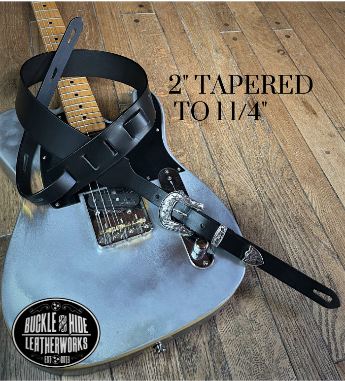 You don't get more classic Western than a handcrafted Glossy black leather guitar strap! Featuring a ornate scroll pattern 3 piece western buckle set in the front position of the strap. Each size of buckle set is similar but not the same, so check out pictures. It's made from 1/8" thick drum dyed cowhide leather and looks great with a vintage "Tele". The main strap is made from a single strip of leather with beveled and .  Made just outside Nashville in Smyrna, TN. 