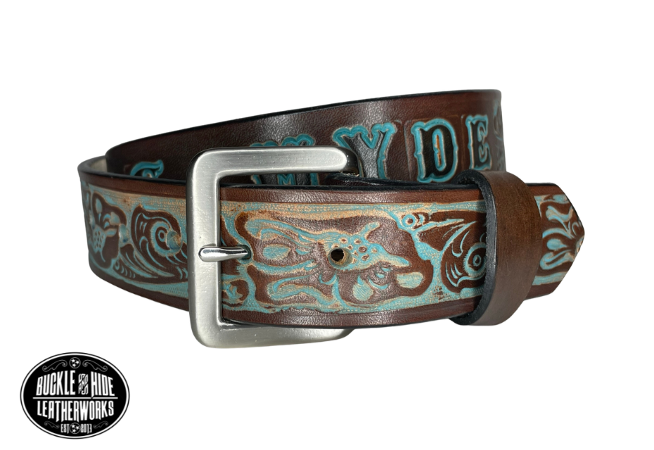 "The Prairie Rose" is a handmade real leather belt made from a single strip of cowhide shoulder leather that is 8-10 oz. or approx. 1/8" thick. It has hand burnished (smoothed) edges and Classic tooled western style flowers embossed and hand colored to look like rustic Brown and Turquoise . The antique nickel plated solid brass buckle is snapped in place with heavy snaps.  This belt is made just outside Nashville in Smyrna, TN.  Belt is 1 1/2" width.