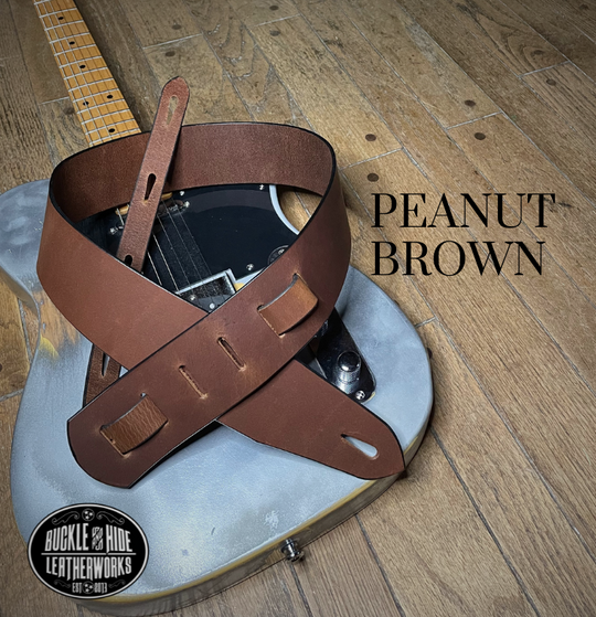 This is our basic "Tone" series. Not Flashy but all Tone! It's made from 1/8" thick drum Peanut Brown or Denim water Buffalo leather and looks great with a vintage Tele, Strat or Acoustic guitars. The main strap is made from a single strip of leather with beveled and .  Made just outside Nashville in Smyrna, TN. Choose a 2" or 2 1/2" wide strap with a classic adjustment style.  